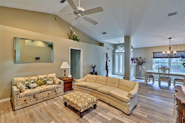 living room with wood-type flooring, ceiling fan with notable chandelier, and high vaulted ceiling