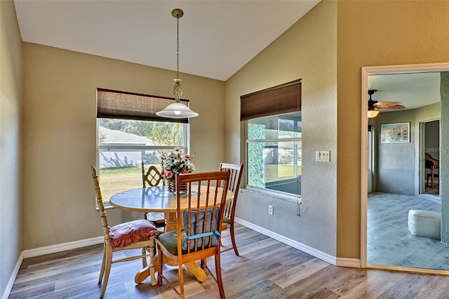 dining area featuring hardwood / wood-style flooring, vaulted ceiling, and ceiling fan