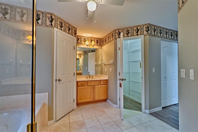 bathroom featuring a washtub, a textured ceiling, vanity, ceiling fan, and hardwood / wood-style floors