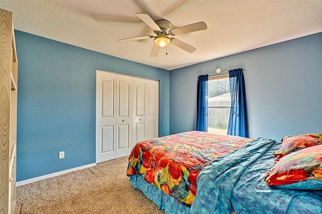 carpeted bedroom with ceiling fan, a closet, and a textured ceiling