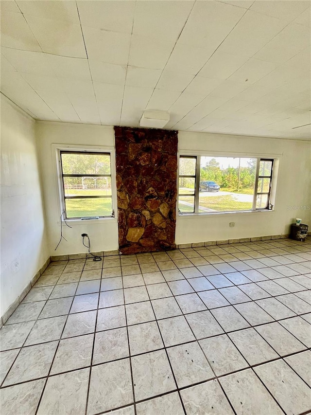 tiled empty room featuring a healthy amount of sunlight