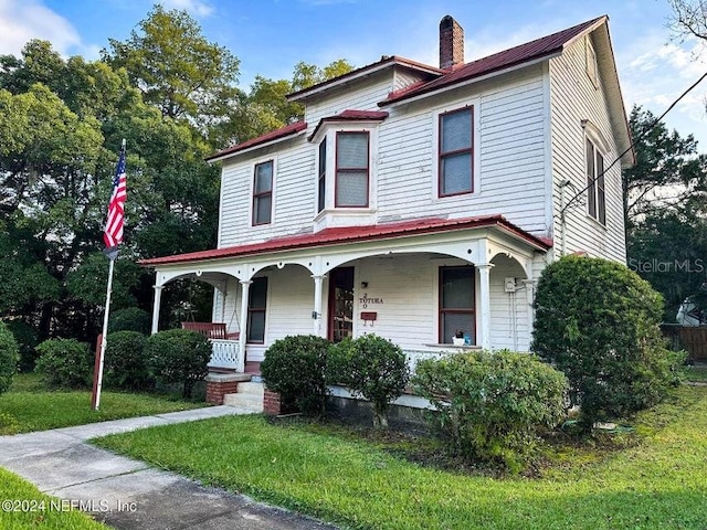 view of front of house featuring covered porch and a front yard