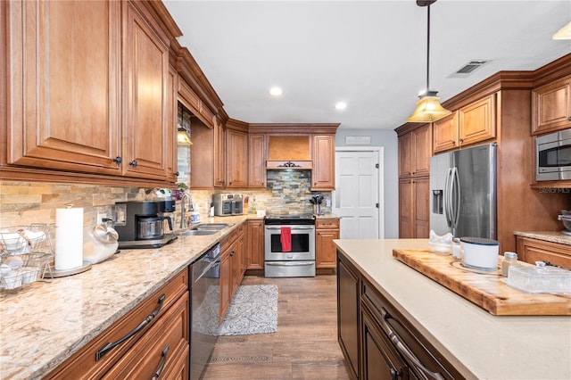 kitchen with sink, tasteful backsplash, dark hardwood / wood-style floors, pendant lighting, and appliances with stainless steel finishes