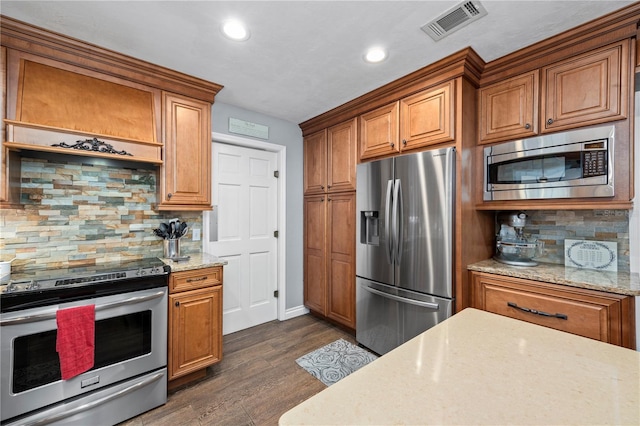 kitchen featuring decorative backsplash, dark hardwood / wood-style flooring, light stone counters, and appliances with stainless steel finishes