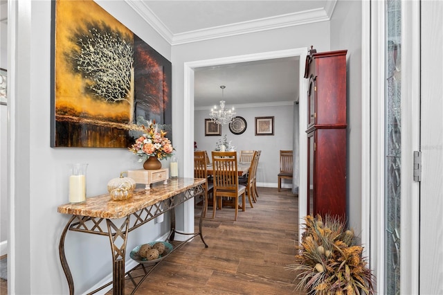 hall with ornamental molding, dark wood-type flooring, and a notable chandelier