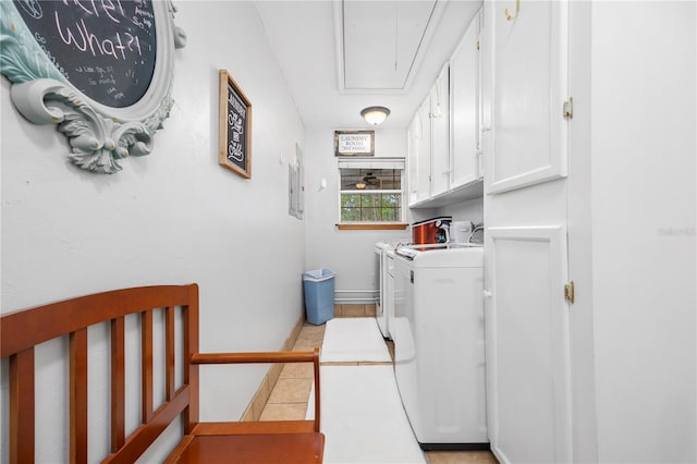 laundry room with washer and clothes dryer, cabinets, and light tile patterned floors