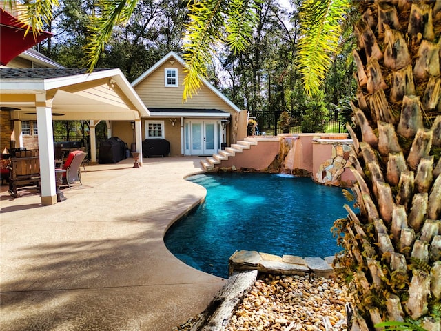 view of swimming pool featuring pool water feature, a patio, grilling area, and french doors