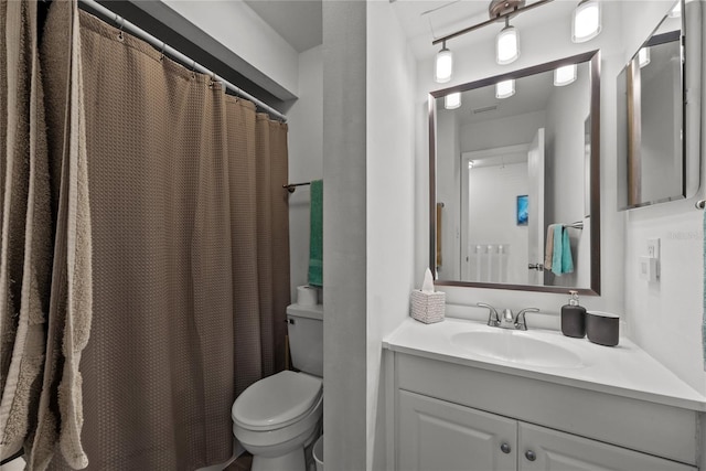 bathroom featuring a shower with shower curtain, vanity, and toilet