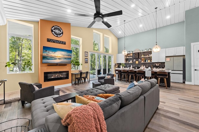 living room with ceiling fan, high vaulted ceiling, wooden ceiling, and light wood-type flooring