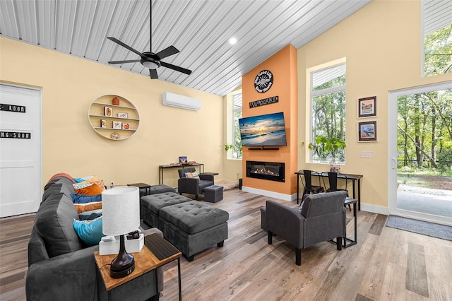 living room featuring a wall mounted air conditioner, hardwood / wood-style flooring, a healthy amount of sunlight, and wood ceiling