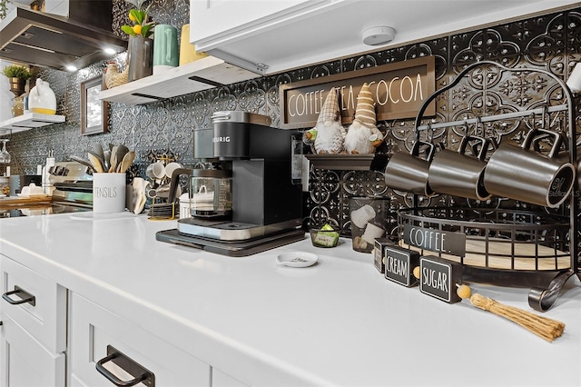 interior details featuring white cabinets, extractor fan, and tasteful backsplash