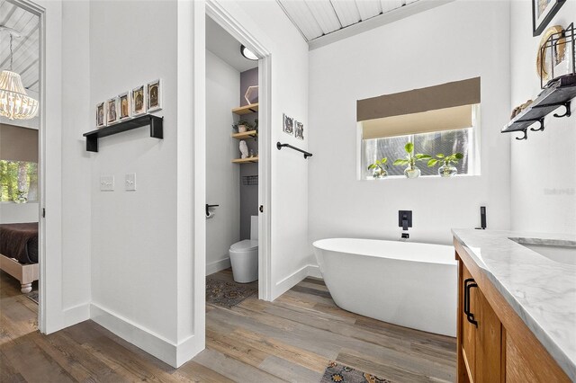 bathroom featuring hardwood / wood-style floors, a tub, and a healthy amount of sunlight