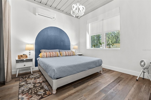 bedroom featuring a chandelier, hardwood / wood-style flooring, an AC wall unit, and wood ceiling