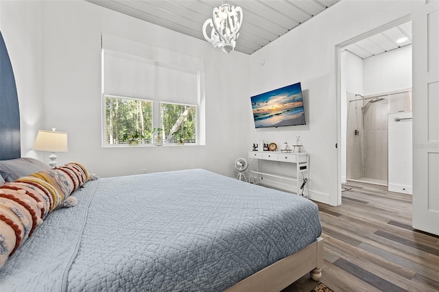 bedroom featuring wood-type flooring and an inviting chandelier