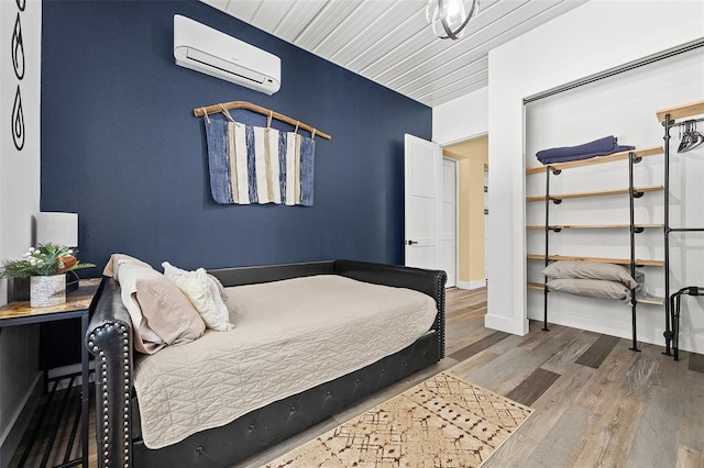 bedroom with hardwood / wood-style floors, wooden ceiling, and a wall mounted air conditioner