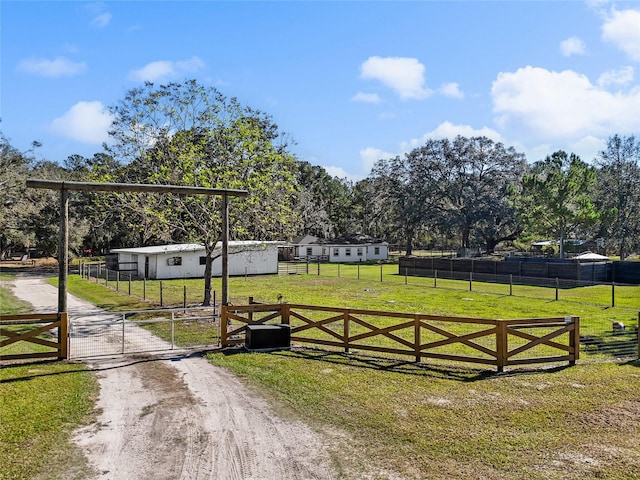 view of gate with a yard and a rural view