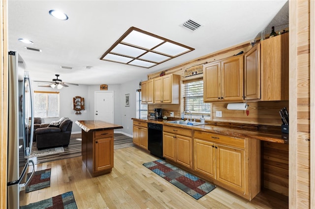 kitchen featuring dishwasher, a center island, sink, stainless steel fridge, and light hardwood / wood-style floors