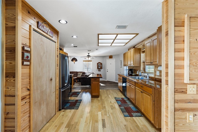 kitchen with stainless steel refrigerator, sink, plenty of natural light, and light hardwood / wood-style flooring