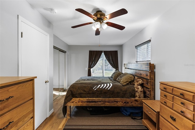 bedroom with a closet, light hardwood / wood-style floors, and ceiling fan