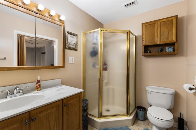 bathroom with toilet, vanity, tile patterned floors, and a shower with door