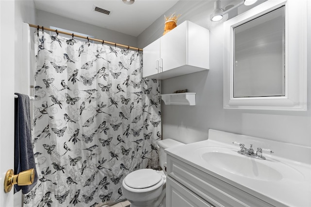 bathroom featuring a shower with shower curtain, vanity, and toilet