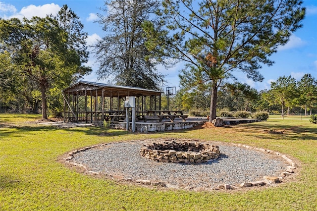 surrounding community featuring a fire pit and a lawn