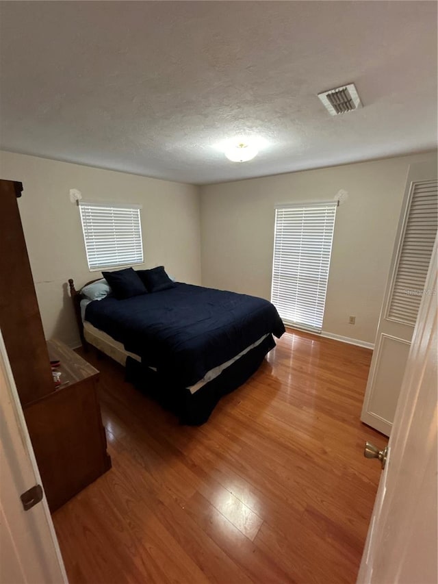 bedroom featuring a textured ceiling and hardwood / wood-style flooring