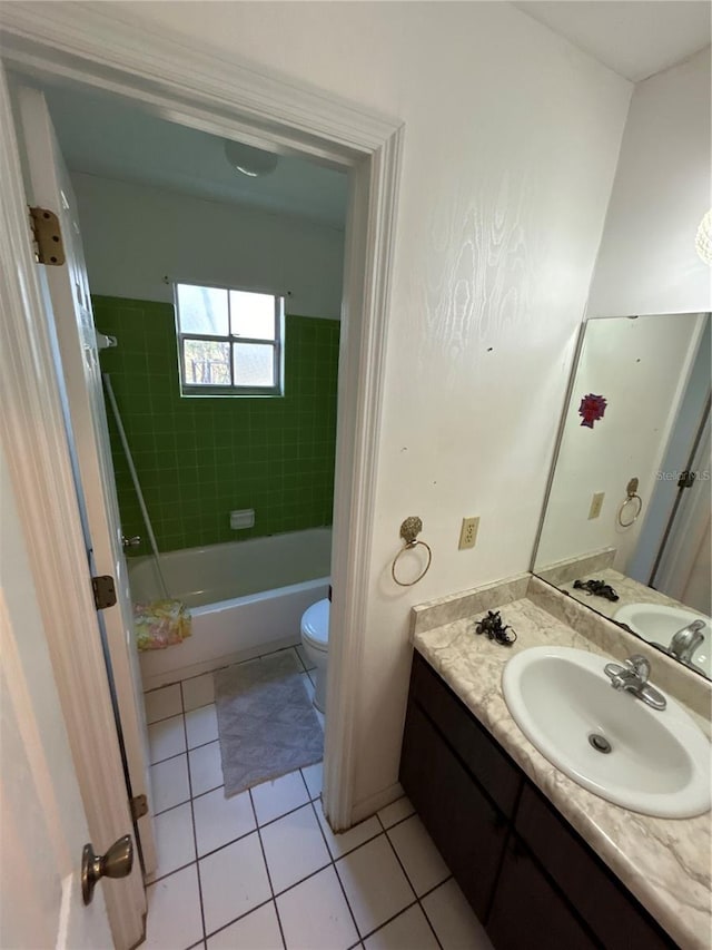 full bathroom featuring tiled shower / bath, tile patterned flooring, vanity, and toilet