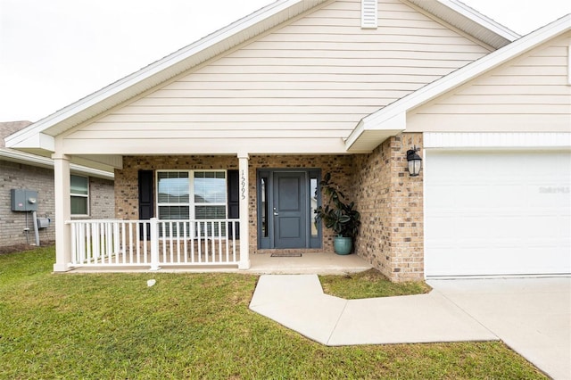 view of front of property with covered porch, a garage, and a front yard