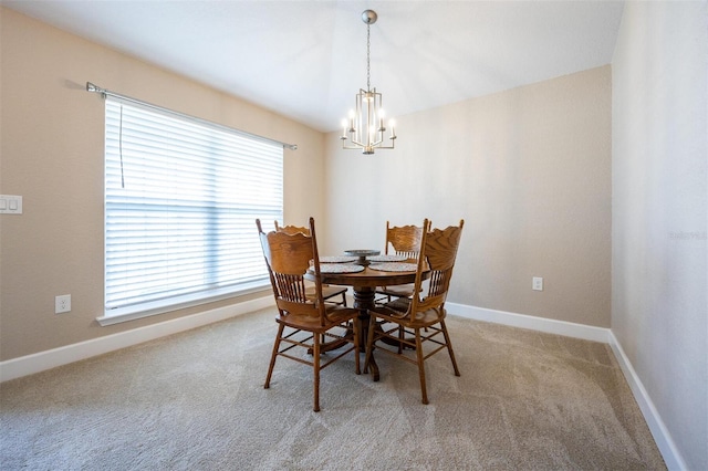 carpeted dining room with a chandelier