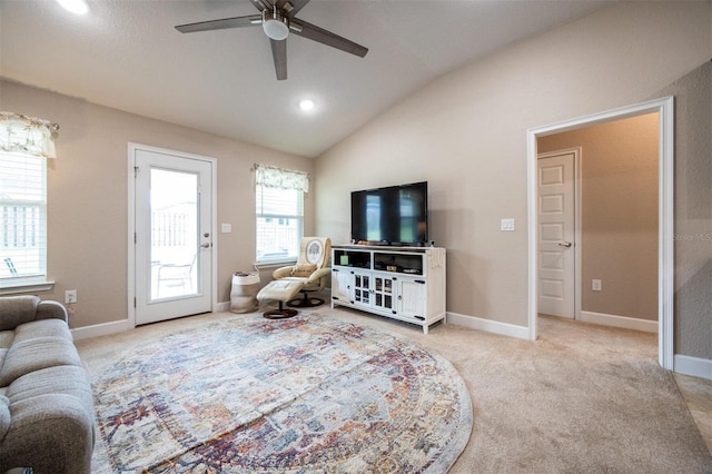 carpeted living room with ceiling fan and vaulted ceiling