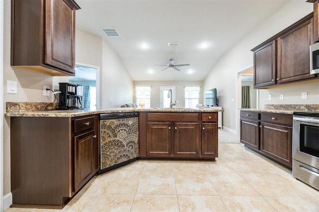 kitchen with dark brown cabinets, appliances with stainless steel finishes, and vaulted ceiling