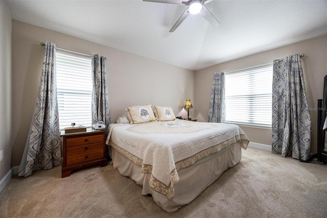 bedroom with ceiling fan, light carpet, and multiple windows