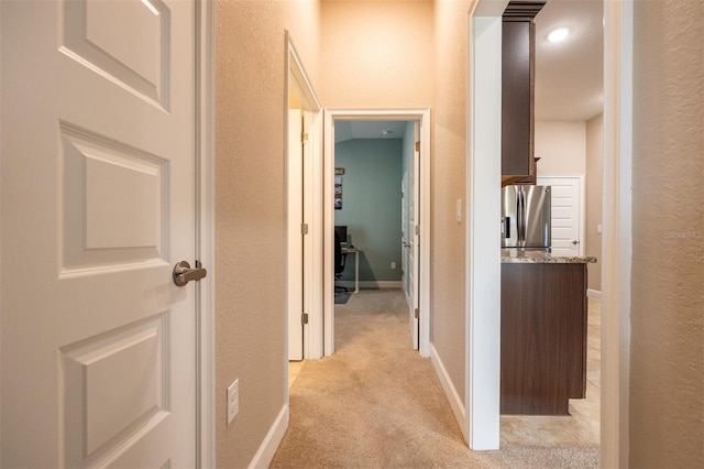 corridor featuring light colored carpet