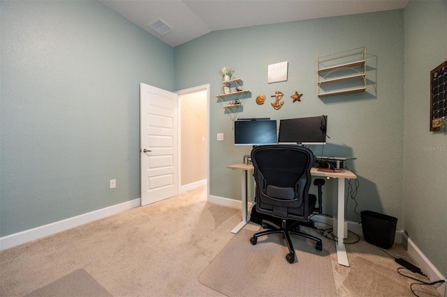 carpeted home office with vaulted ceiling