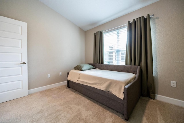 bedroom featuring light carpet and lofted ceiling