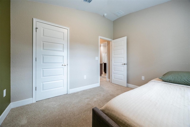 bedroom with light carpet and lofted ceiling