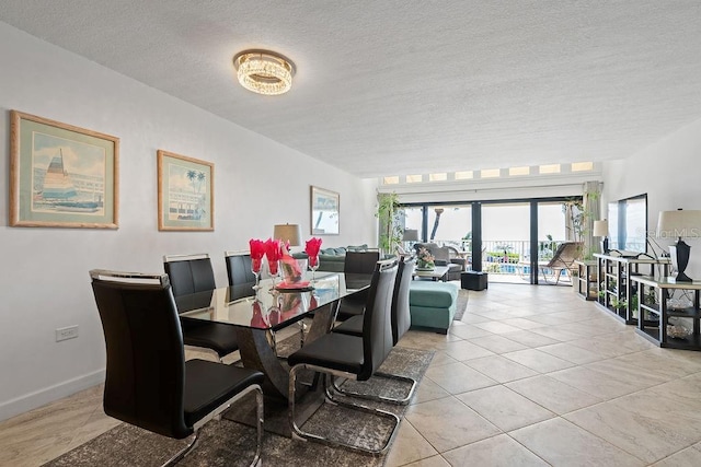 dining area with light tile patterned floors and a textured ceiling