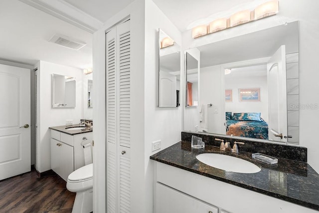 bathroom with hardwood / wood-style floors, vanity, and toilet