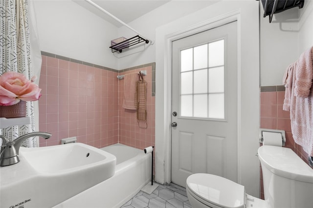 full bathroom featuring sink, tile walls, tile patterned flooring, toilet, and tiled shower / bath