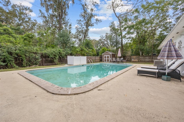 view of pool featuring a storage shed and a patio