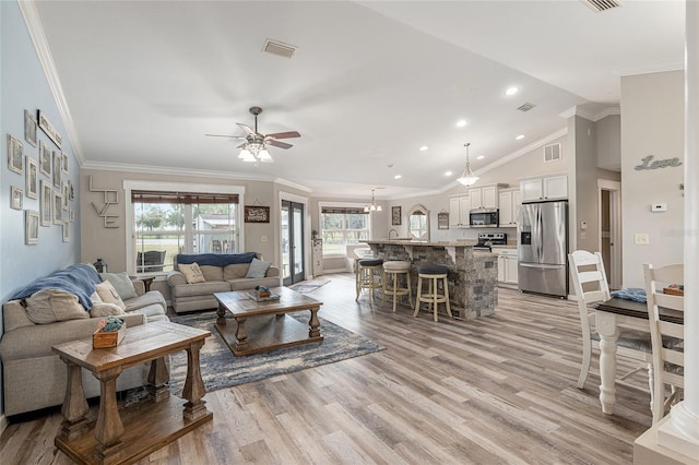 living room featuring ceiling fan, light hardwood / wood-style flooring, ornamental molding, and vaulted ceiling