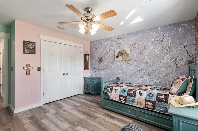 bedroom with a closet, ceiling fan, and light wood-type flooring