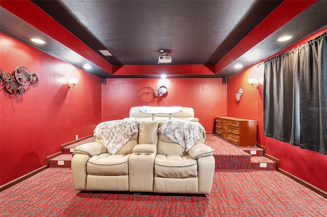 carpeted cinema featuring a tray ceiling