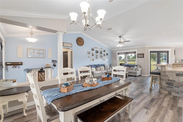 dining space with ceiling fan, ornate columns, crown molding, hardwood / wood-style floors, and vaulted ceiling