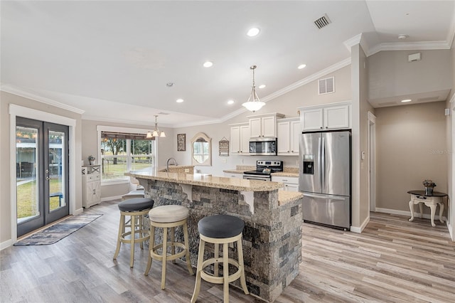 kitchen featuring a kitchen bar, a spacious island, white cabinets, stainless steel appliances, and lofted ceiling