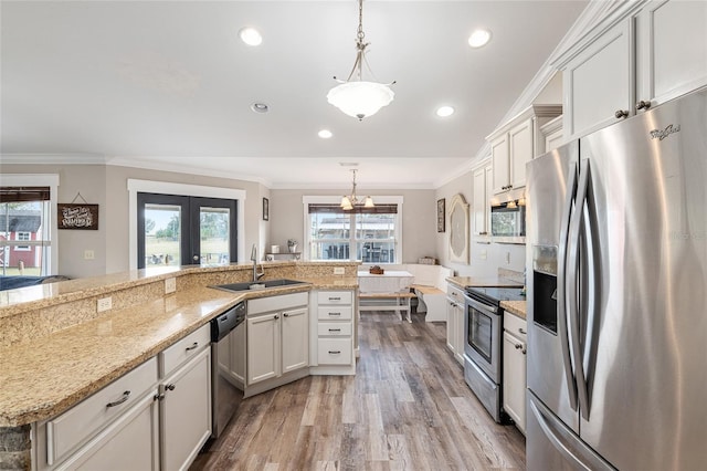 kitchen with sink, french doors, hanging light fixtures, and appliances with stainless steel finishes