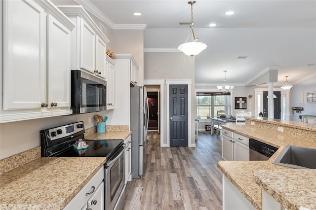 kitchen featuring pendant lighting, white cabinetry, light stone countertops, and appliances with stainless steel finishes