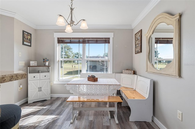 dining space featuring breakfast area, a chandelier, crown molding, and dark hardwood / wood-style flooring