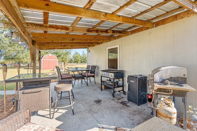 view of patio / terrace with a storage shed and a grill